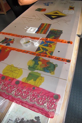 textiles are glued on to a large piece of paper