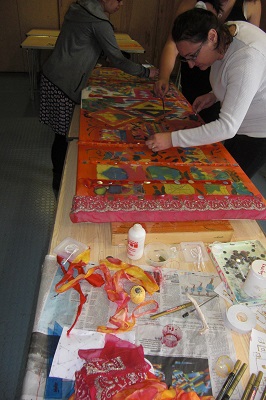 Families adding textiles and sequins to the artwork