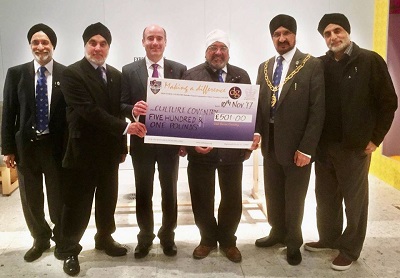 A group of men hold a giant cheque for £501