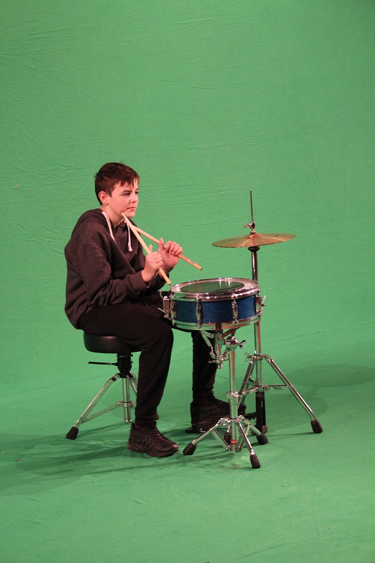 boy with drum kit against green screen 